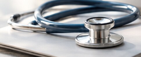 Close detail of a stethoscope resting on a pale surface